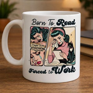 Könnte beinhalten: Ein weißer Keramikbecher mit einer Illustration im Retro-Comic-Stil, die eine weinende Person beim Lesen neben einer schwarzen Katze zeigt. Der Text lautet Born To Read, Pages Over Paychecks und Forced to Work in blauer Schrift.