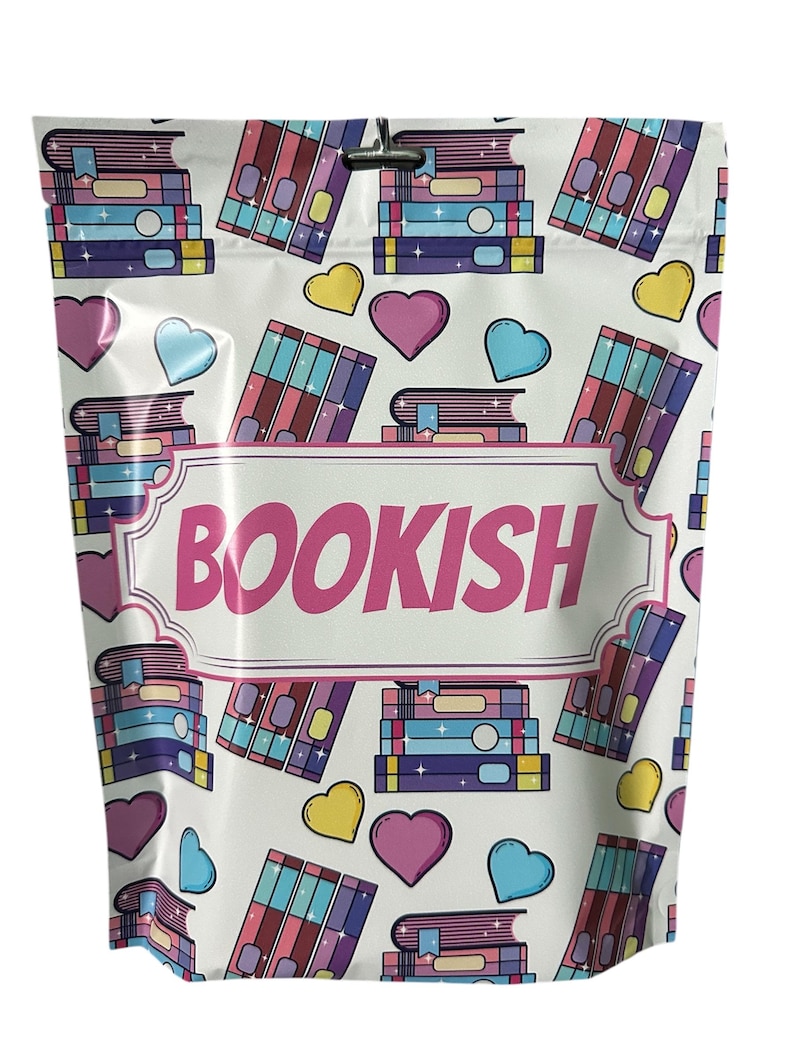 May include: White resealable bag with a pink and white label that says "BOOKISH". The bag has a repeating pattern of stacks of colorful books and hearts.