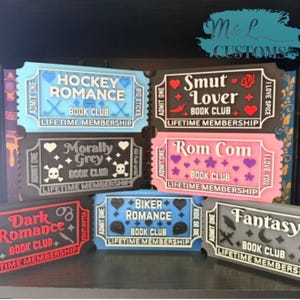 May include: A collection of six rectangular signs shaped like admission tickets, each featuring a specific book club theme including Hockey Romance, Smut Lover, Morally Grey, Rom Com, Dark Romance, Biker Romance, and Fantasy with various icons.