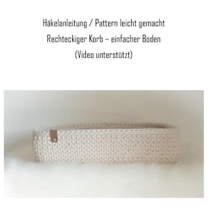 Könnte beinhalten: Ein weißer rechteckiger Korb aus Häkelarbeit mit einem braunen Ledergriff. Der Korb steht auf einer weißen, flauschigen Oberfläche. Der Text "Hakeanleitung / Pattern leicht gemacht" ist über dem Korb zu sehen.