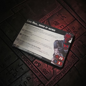 May include: A rectangular game card titled Lord Maul, Driven by Hatred, featuring an illustration of a red and black horned character. The card displays game rules, ability text, and two circular icons with the numbers 20 and 3 in red circles.