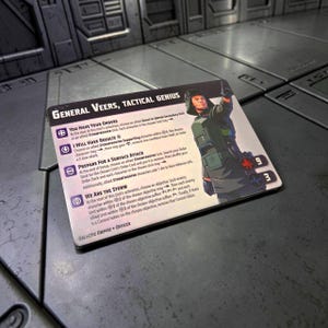 Peut inclure: Une carte rectangulaire représentant le Général Veers, Tactical Genius, de l'Empire Galactique. La carte présente un portrait d'un personnage en uniforme vert. Le texte comprend "You Have Your Orders" et "We Are The Storm".