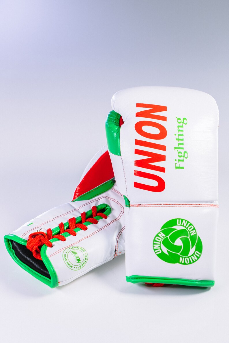 May include: White boxing gloves with red and green accents. The gloves have the word "UNION" in red and "Fighting" in green on the back. The gloves are laced up and have a green and white logo on the wrist.
