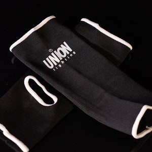 May include: Black elbow pads with white trim and the text "UNION fighting" in white.