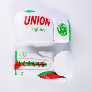 May include: A pair of white boxing gloves with green and red trim. The gloves have the text "UNION Fighting" on one glove and a green logo on the other.