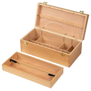 May include: A light-colored wooden box with a hinged lid and a removable tray. The box is divided into several compartments and secured with brass-colored hardware. The open lid reveals the interior, showcasing the box's organizational design.