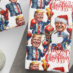 May include: Gift wrap featuring a cartoon image of a man wearing a Santa hat and boxing gloves, with the words "Merry Christmas" in red script. The wrapping paper has a white background and is decorated with colorful Christmas lights.