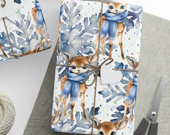 May include: White wrapping paper with a repeating pattern of blue-eyed deer wearing blue scarves and snowflakes. The deer are standing on a white background with colorful confetti.