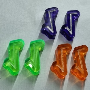 Op de afbeelding: Zes plastic spelstukken in de vorm van een pijl. Twee zijn groen, twee zijn oranje en twee zijn paars.