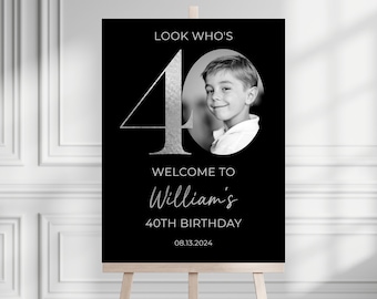 May include: Black and white welcome sign with a silver 40 and the text "Look Who's" and "Welcome to William's 40th Birthday 08.13.2024". A black and white photo of a boy is in the center of the sign.