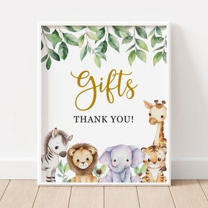 May include: A white sign with a gold "Gifts" sign and the words "Thank You!" surrounded by green leaves and a variety of animal illustrations including a zebra, lion, elephant, tiger, and giraffe.