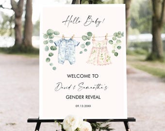 May include: A welcome sign for a gender reveal party. The sign features the text "Hello Baby!" above watercolor illustrations of baby clothes hanging on a clothesline. The sign also includes the text "Welcome to David & Samantha's Gender Reveal" and the date.