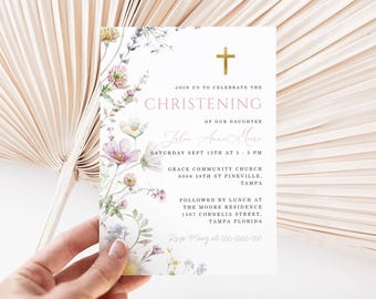 Puede incluir: Una tarjeta de invitación de bautizo blanca con ilustraciones florales y una cruz dorada. El texto dice "Únase a nosotros para celebrar el bautizo de nuestra hija". Incluye detalles del evento.