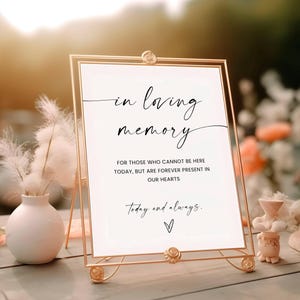 Puede incluir: Un letrero con marco dorado con las palabras "in loving memory" en una elegante escritura. El letrero incluye el texto "Para aquellos que no pueden estar aquí hoy, pero están para siempre presentes en nuestros corazones" y "Hoy y siempre."