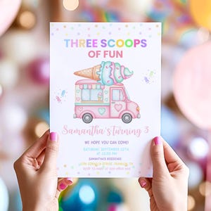 以下が含まれることがあります： 「THREE SCOOPS OF FUN」と「Samantha's turning 3」の文字が入ったパステルピンクの招待状。ピンクのアイスクリームトラックのイラストが特徴で、上部に大きなアイスクリームコーンが付いています。招待状は両手で持たれています。