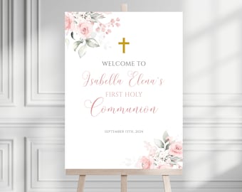 May include: A white welcome sign with pink floral designs and a gold cross. The text reads "Welcome to Isabella Elena's First Holy Communion September 13th, 2024".