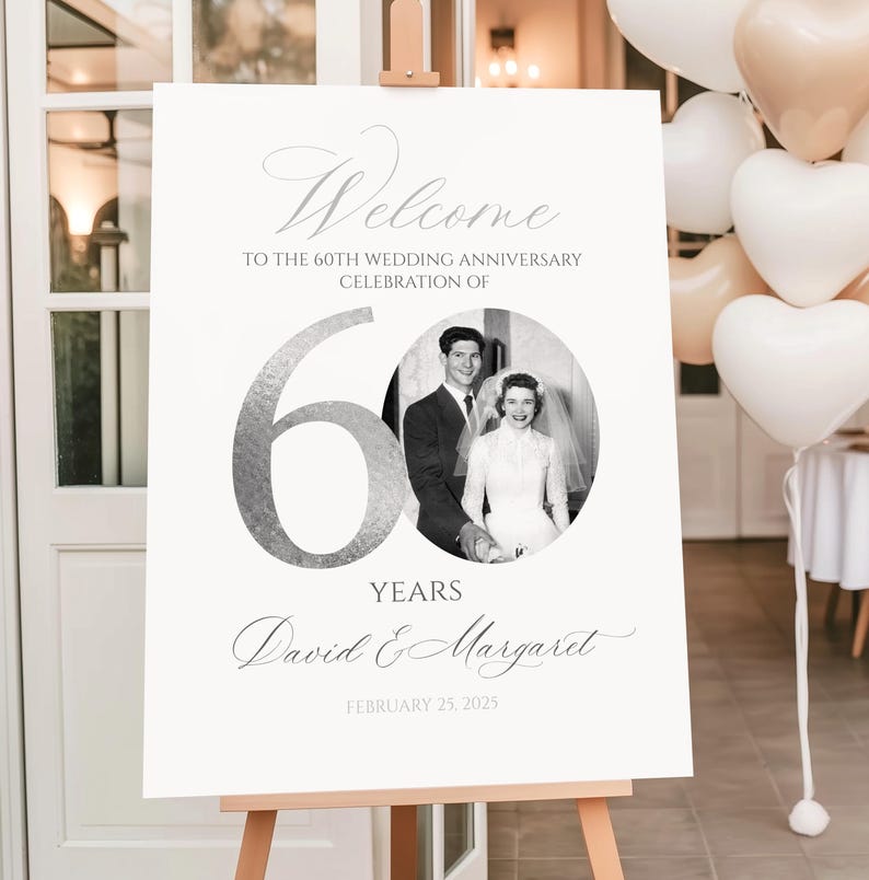 May include: A white rectangular welcome sign for a 60th wedding anniversary celebration. The sign features the text Welcome to the 60th wedding anniversary celebration of, a large silver number 60, a circular black and white photo of a couple, and the names David & Margaret with the date February 25, 2025.