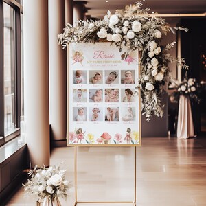 May include: A rectangular sign on a gold metal stand featuring the text Rosie, My Fairy First Year, Sept 13th, 2024, 11:30 AM, and twelve baby photographs labeled one through twelve, decorated with watercolor fairy and mushroom illustrations.