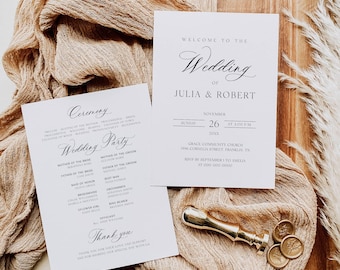 May include: Wedding invitation suite featuring two white cards with elegant calligraphy. One card reads "Welcome to the Wedding of Julia & Robert" with the date and time. A gold wax seal and a wooden board complete the scene.