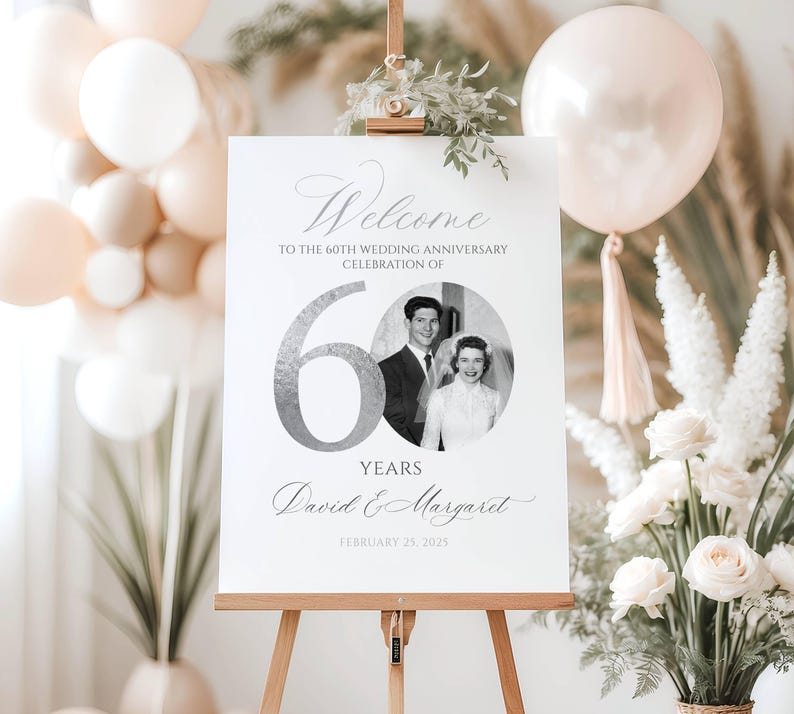 May include: A white rectangular sign on a wooden easel featuring the text Welcome to the 60th wedding anniversary celebration of, a large silver number 60, a circular black and white photo of a couple, the names David & Margaret, and February 25, 2025.