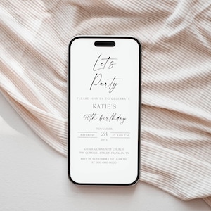 Op de afbeelding: Een smartphone toont een uitnodiging voor een verjaardagsfeest. De uitnodiging luidt "Let's Party" en kondigt Katie's 40e verjaardag aan op 28 november om 15:00 uur. De telefoon ligt op een neutrale, getextureerde achtergrond.