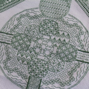 May include: Green cross-stitch pattern with a circular design featuring multiple concentric circles and geometric shapes.