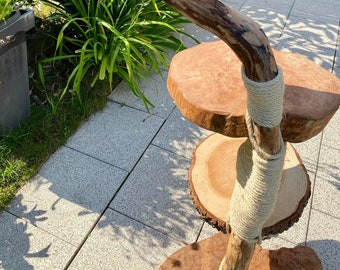May include: A three-tiered wooden cat tree made from natural branches, with each platform being a circular slice of wood. The branches are wrapped in natural twine.