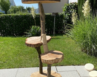 May include: A three-tiered cat tree made from natural wood with a rope-wrapped post. The tree has a wide base and three circular platforms. The tree is outdoors on a patio.