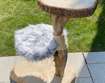 Peut inclure: Un arbre à chat en bois avec deux plateformes. La plateforme supérieure est une tranche de bois naturel avec une corde enroulée autour du bord. La plateforme inférieure est une tranche de bois naturel avec un coussin en fausse fourrure blanche et noire. L'arbre est fait de branches de bois naturel.