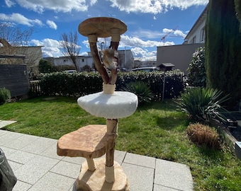 Peut inclure: Un arbre à chat en bois avec trois plateformes, recouvertes de fausse fourrure et de corde de sisal. L'arbre est à l'extérieur sur un patio avec une pelouse verte en arrière-plan.