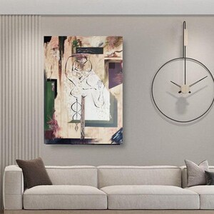 May include: Abstract painting with a white figure in the center, surrounded by geometric shapes in shades of brown, green, and purple. The painting is hanging on a wall in a living room setting with a couch and a clock.