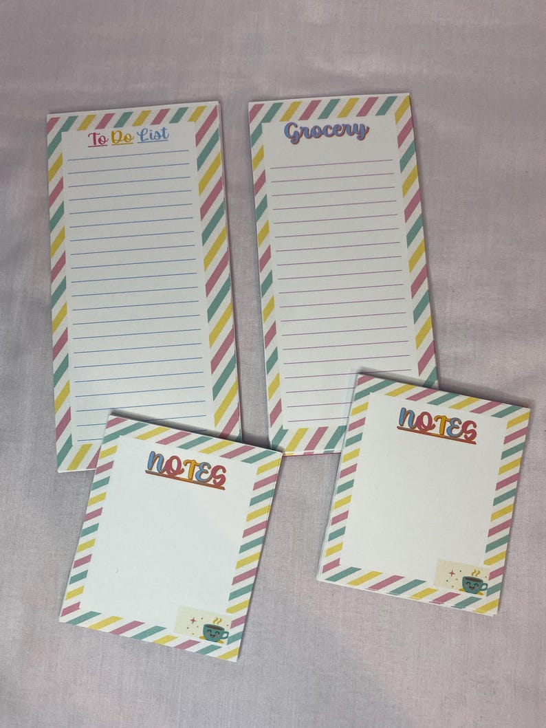 May include: Four notepads with lined pages and colorful diagonal striped borders. Two pads read "To Do List" and "Grocery" in pastel lettering. The other two pads say "Notes" and feature a small sticker with a coffee cup.