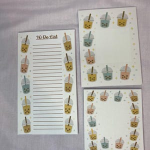 May include: Three white notepads with a bubble tea theme. One notepad is a to-do list with lines and bubble tea illustrations. The other two notepads have bubble tea illustrations around the edges. The bubble tea illustrations are in shades of brown, pink, blue, and yellow.
