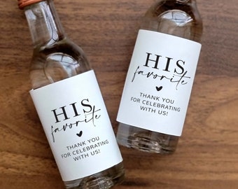 May include: Two small glass bottles with white labels that say "HIS favorite" with a small heart symbol. The labels also say "Thank you for celebrating with us!"