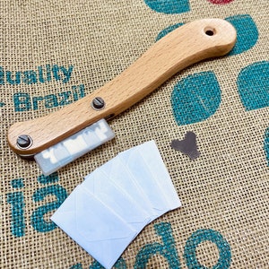 Peut inclure: Un coupe-café en bois avec une lame argentée et une pile d'enveloppes en papier blanc sur un fond en toile de jute.
