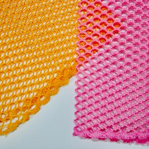 May include: Two pieces of fabric with a mesh pattern. One piece is yellow and the other is pink.