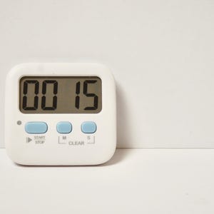 May include: A white digital kitchen timer with a blue display showing 00:15. The timer has buttons labelled "Start/Stop", "M", "Clear", and "S".