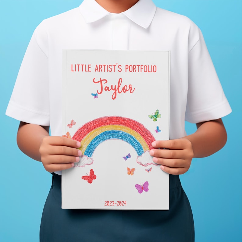 Custom art album featuring toddler drawings and childhood creativity. Close-up of personalized cover with child’s name and date on art keepsake book.