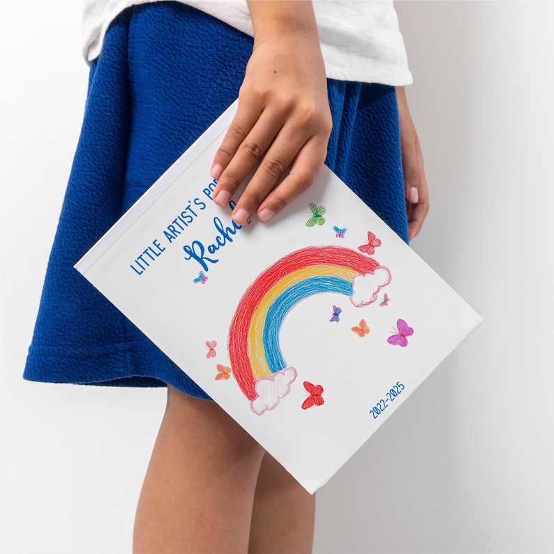 Detail shot of NEVIA paper inside child art book, vibrant print quality.
Handmade kids art portfolio showing personal notes and drawing titles.