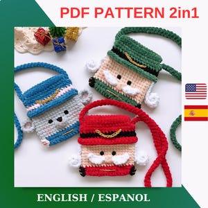 以下が含まれることがあります： 肩ひも付きのクリスマスモチーフのクロシェバッグ3つ。バッグは赤、緑、青で、白ひげと口ひげのあるクロシェの顔がついています。バッグには「PDF PATTERN 2in1」と「ENGLISH / ESPANOL」のラベルが付いています。