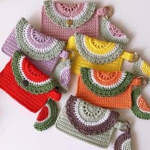 Puede incluir: Seis monederos de ganchillo con forma de sand&iacute;a en una variedad de colores, incluyendo rosa, morado, amarillo, naranja y verde. Cada monedero tiene un peque&ntilde;o amuleto de sand&iacute;a de ganchillo.