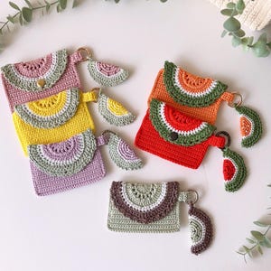 Puede incluir: Cinco monederos de ganchillo con forma de sand&iacute;a con llaveros a juego. Los monederos son de color rosa, amarillo, verde, rojo y marr&oacute;n. Cada monedero tiene un llavero de ganchillo con forma de rodaja de sand&iacute;a.