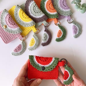 Puede incluir: Un conjunto de seis monederos de ganchillo con forma de sand&iacute;a con llaveros a juego. Los monederos son de varios colores, incluyendo rosa, amarillo, verde, naranja y morado. Cada monedero tiene un llavero de ganchillo con forma de rodaja de sand&iacute;a.