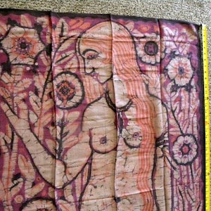 Puede incluir: Panel de tela con una figura desnuda y diseño floral. La obra presenta una mujer con cabello largo y suelto y un patrón floral en tonos rosa, marrón y crema. El panel mide aproximadamente 76 cm de largo.