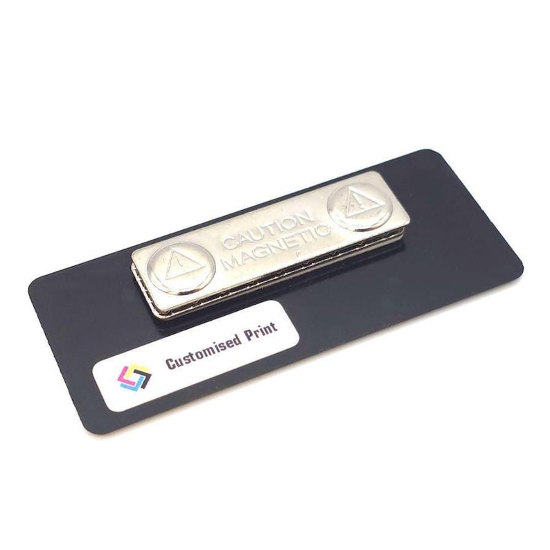 May include: A black rectangular name tag with a silver magnetic clasp. The clasp is labeled "CAUTION MAGNETIC" and features two circular emblems. A white sticker at the bottom reads "Customised Print" with a colorful logo.