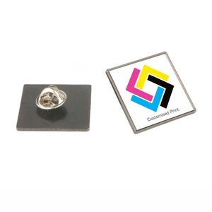 May include: A square metal pin with a white background and a colourful CMYK logo. The text "Customised Print." is below the logo.