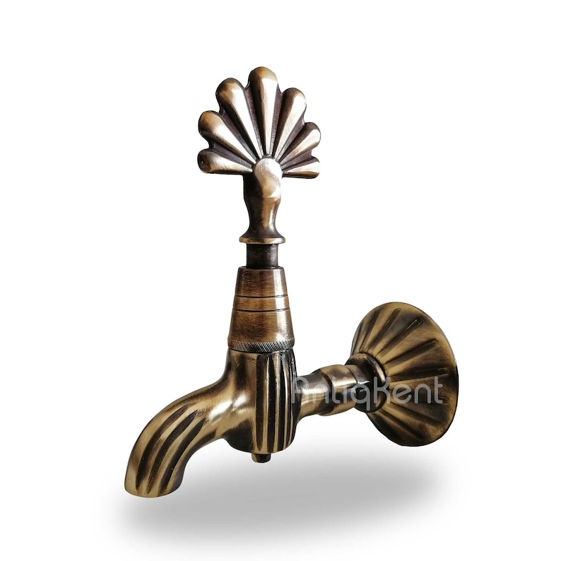 May include: Antique brass faucet with a decorative fan-shaped spout and a wall mount. The faucet has a vintage design and a distressed finish.