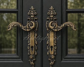 May include: A pair of ornate antique brass door handles with intricate scrollwork and floral detailing mounted on a matte black double door. Each handle features a curved lever and a vertical backplate with a keyhole cutout at the bottom.
