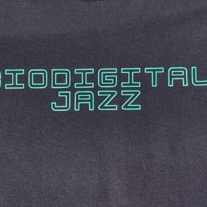 May include: Black t-shirt with a teal green outline of the text "Biodigital Jazz".