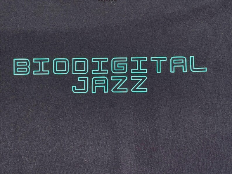 May include: Black t-shirt with a teal green outline of the text "Biodigital Jazz".